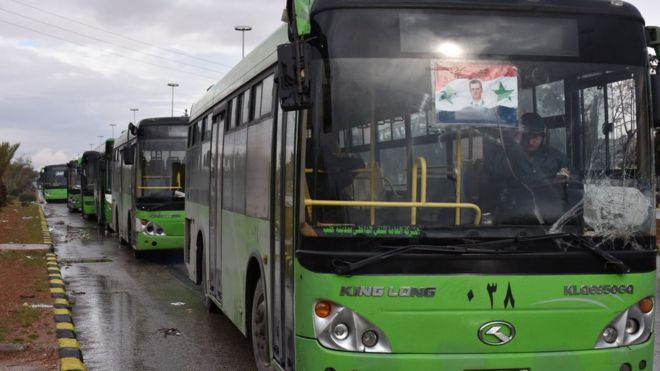 Buses which will be used to evacuate civilians leaving from rebel-held areas of Aleppo are seen waiting on 14 December 2016