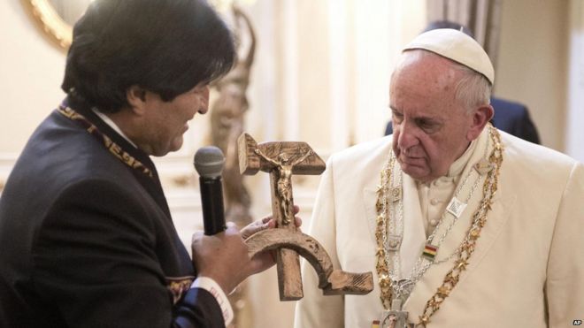 Pope Francis is presented with a gift of a hammer and sickle-shaped crucifix