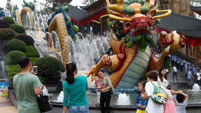 Visitors take photos beside a dragon fountain at an outdoor theme park of the newly-opened Wanda Cultural Tourism City or "Wanda City" in the eastern city of Nanchang in Jiangxi Province, China, 28 May 2016
