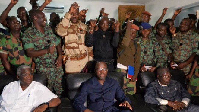 Waziri wa Ulinzi, Alain Richard Donwahi (aliyeketi kati kati) alizuiliwa kwa saa kadhaa na wanajeshi walioasi
