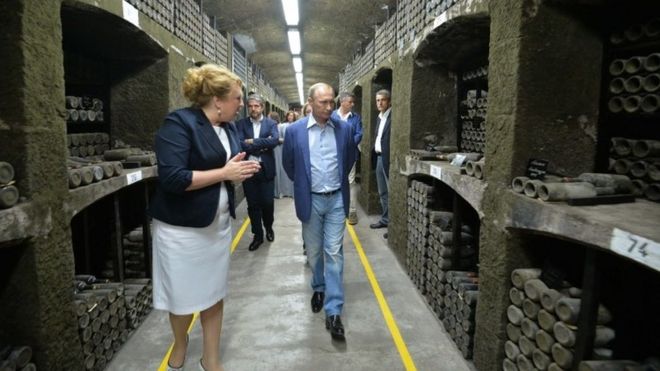 Russia's President Vladimir Putin (C) and Italy's former Prime Minister Silvio Berlusconi (unseen) examine a wine depository of Massandra winery in Yalta, Crimea (11 September 2015)