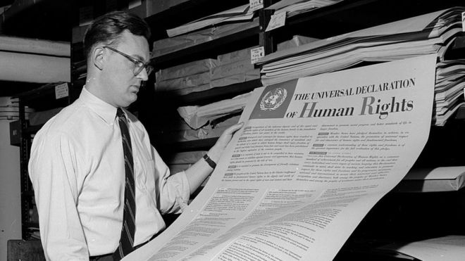 Homem contempla a Declaração Universal dos Direitos Humanos, um dos primeiros documentos publicados pela ONU