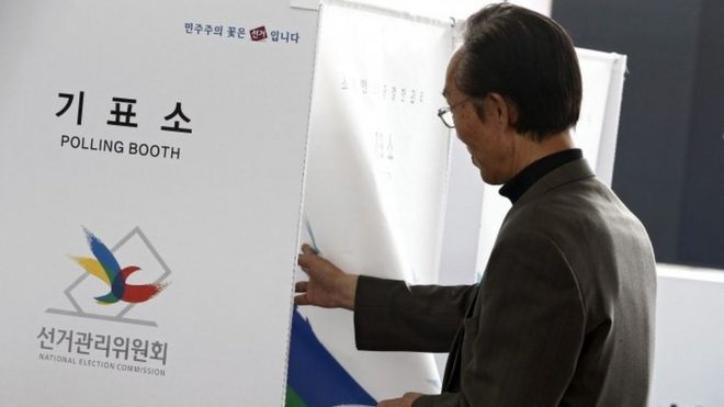 A South Korean man enters a polling booth to cast his vote at polling station in Seoul (08 April 2016)