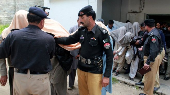 Police lead away arrested members of the jirga outside a court in Abbottabad, Pakistan. 5 May 2016