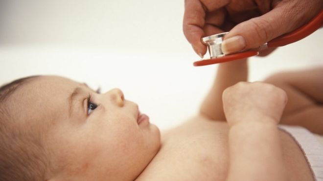 Baby being looked at by a paediatrician