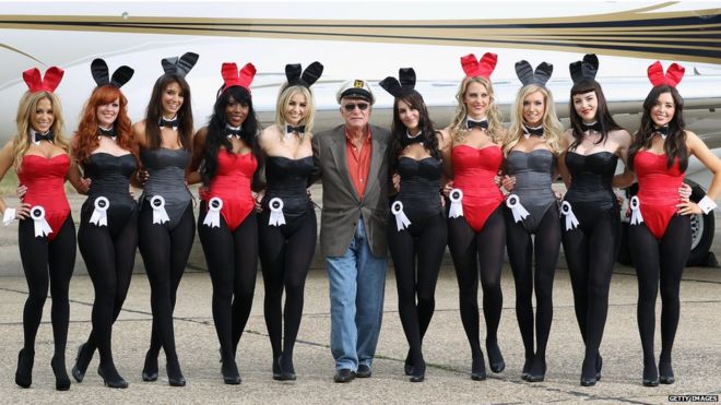 Playboy founder Hugh Hefner (centre) arrives at Stansted Airport in England