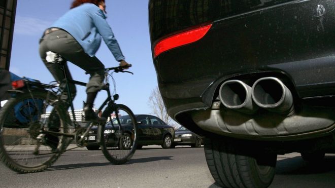 Woman cycling past car in Berlin, file picture