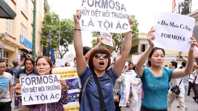 Vietnamese protesters hold banners reading "Formosa destroys the environment, which is a crime" during a rally in Hanoi o­n 1 May, 2016