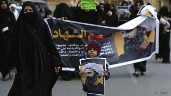 Bahraini protesters hold pictures of Sheikh Nimr al-Nimr in Daih, Bahrain, 3 Jan