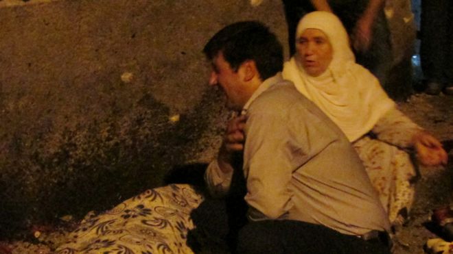 A man and woman mourn next to a body of one the victims in Gaziantep