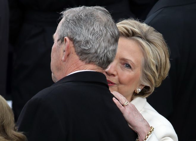 Hillary Clinton, who lost the presidential race to Trump, whispers into the ear of former president George W Bush ahead of the inauguration