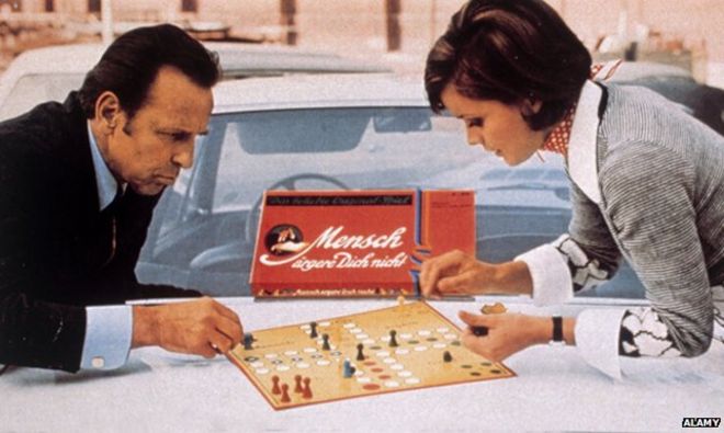 Man and woman play board game Mensch Aergere Dich Nicht