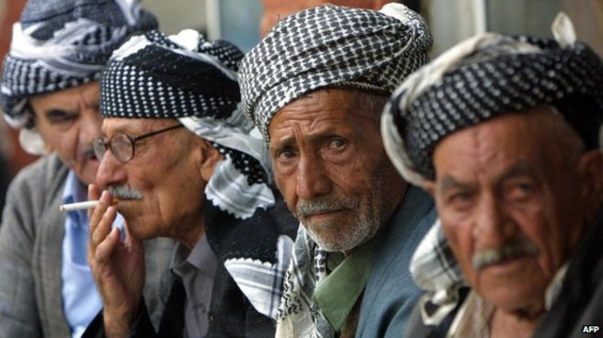 Kurdish men sit in the bazaar in Sulaimaniya, Iraq (17 October 2002)