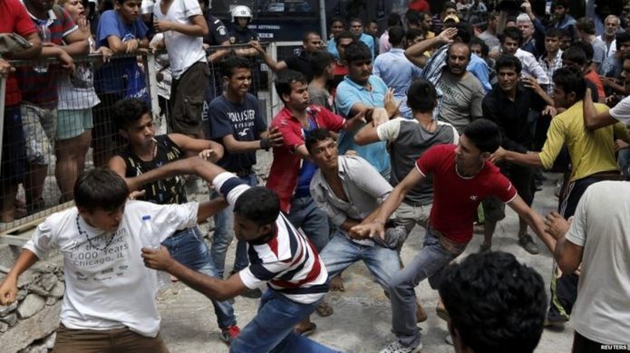 Pakistani, Iranian and Afghan migrants scuffle outside the police station on Kos 15/08/2015