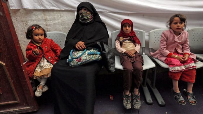 Women and children sitting in a temporary medical centre