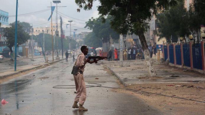 A Somali government soldier takes position during gunfire after a suicide bomb attack outside a hotel in Somalia's capital Mogadishu on 25 June