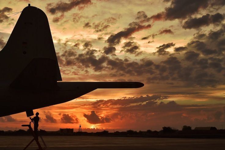 An airman makes technical checks to an anti-piracy reconnaissance plane at sunset in Djibouti