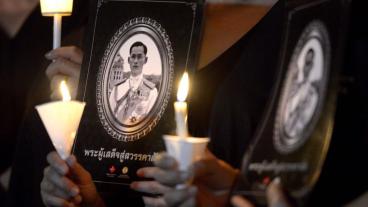 Thai people hold candles during a vigil in honour of late Thai King Bhumibol Adulyadej at a park in Bangkok on November 30, 2016