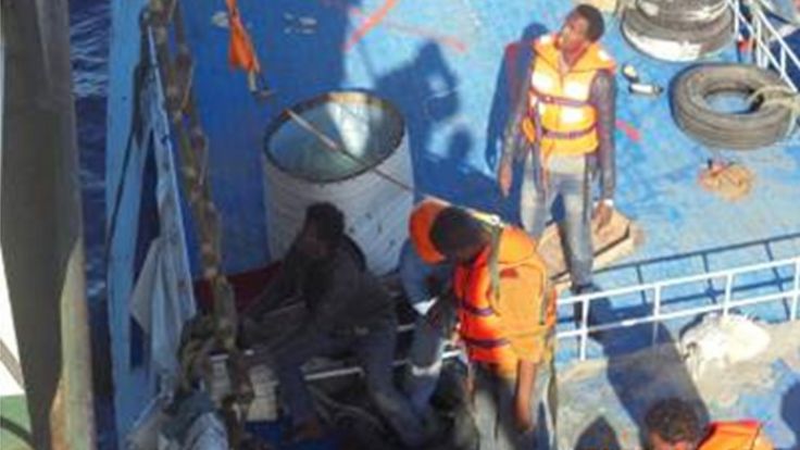 Rescued migrants are taken off the boat