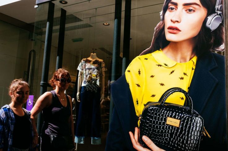 Dos mujeres caminan frente a una tienda en París.