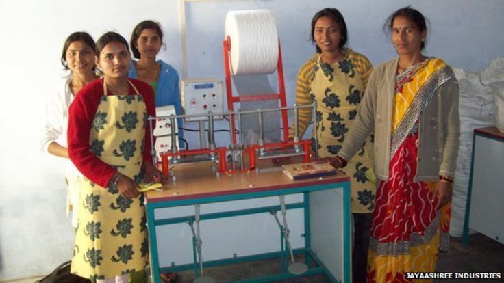 Indian school girls stand before the sanitary pad machine