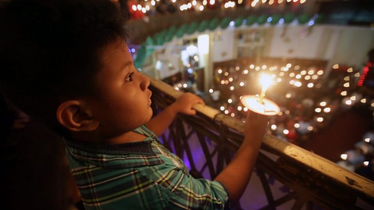 An Indonesian boy holds the candle during a Christmas Eve mass at the Immanuel church in Jakarta, Indonesia, 24 December 2015