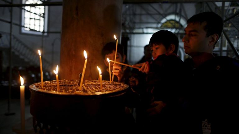 Worshippers light candles inside the Church of the Nativity, the site revered as the birthplace of Jesus, during Christmas celebrations in the West Bank town of Bethlehem December 24, 2015.