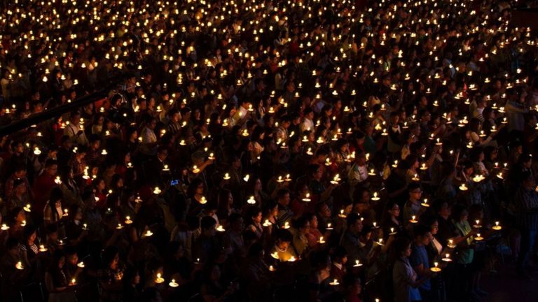 Christian faithfuls hold candles as they attend a mass service on Christmas eve in Surabaya on December 24, 2015.