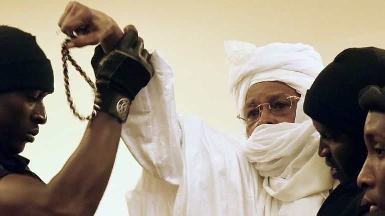 Habre in chains at his trial with face covered