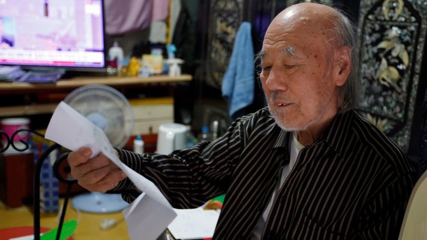 South Korean Kim Wu-jong, 87, who will travel to North Korea to meet his younger sister, looks at a document from the Red Cross during the interview at his home in Seoul, South Korea (15 October 2015)