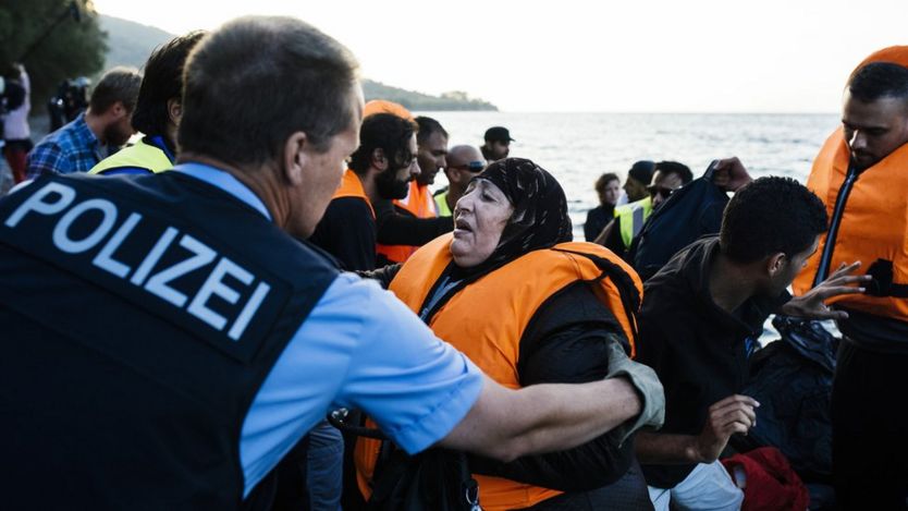 Frontex officer helping migrants on Lesbos, 17 Oct 15
