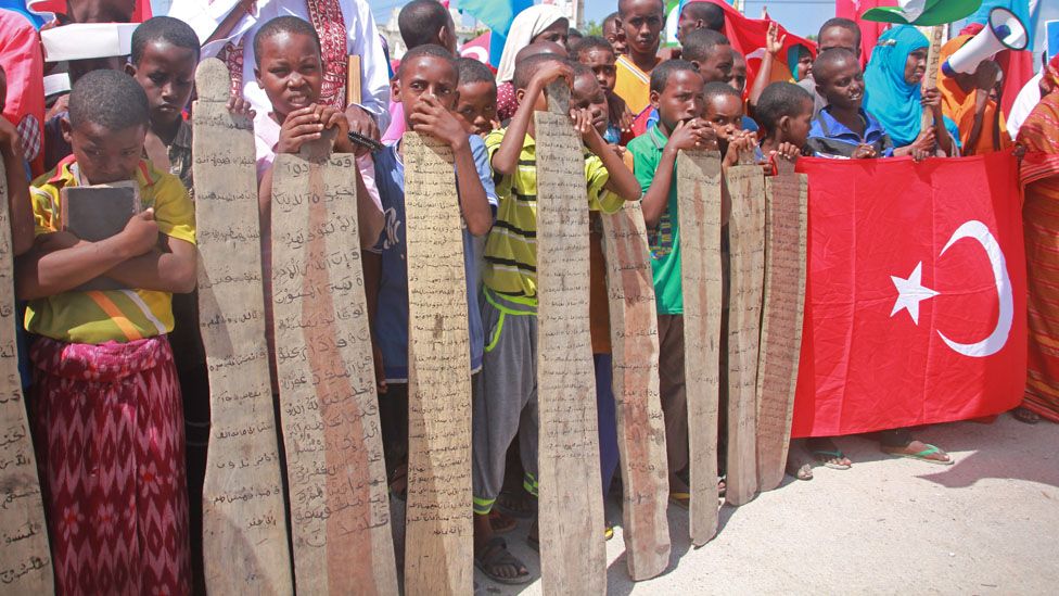 Women hold a Turkish flag, and young children display verses of the Koran written on wooden planks as they join Somalis protesting against an attempted military coup in Turkey, in Mogadishu, Somalia, Saturday, 16 July 2016