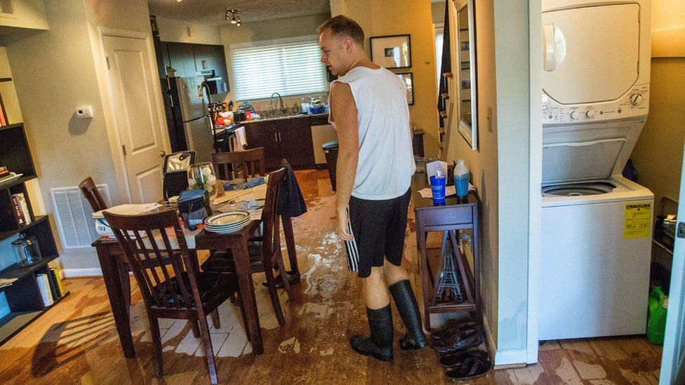 Jeremy Spearman checks on flood damage to his Parkside Five Points Townhomes apartment in Raleigh, N.C., after Hurricane Matthew caused downed trees and flooding Sunday, Oct. 9, 2016