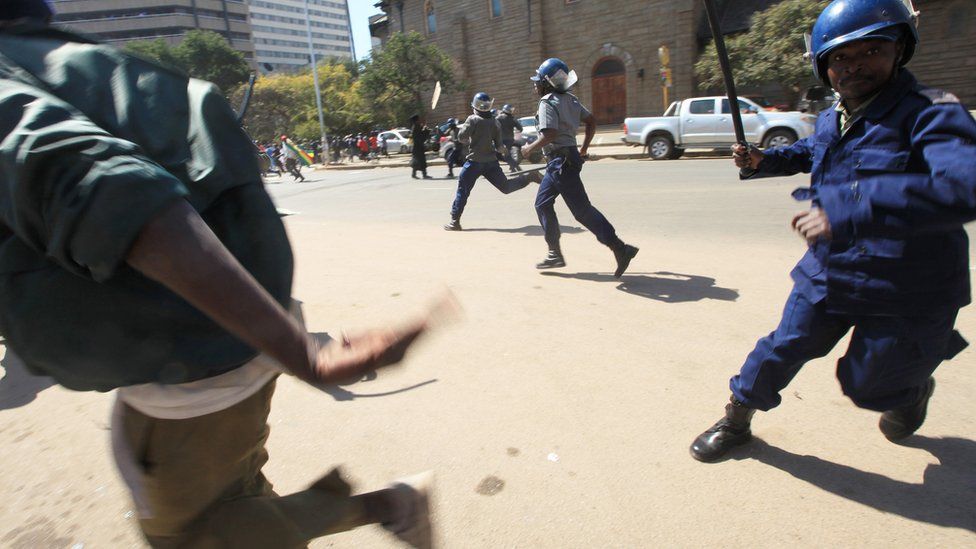 A policeman with a baton chasing a protester in Harare, Zimbabwe - Wednesday 3 August 2016
