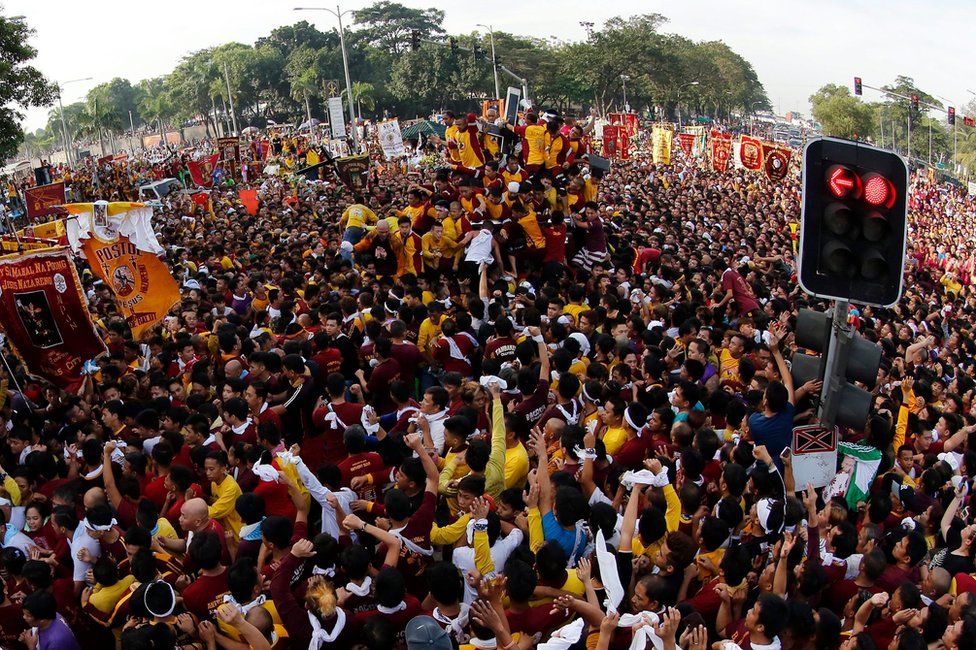 Huge crowds of Filipino devotees jostle to reach the statue of the Black Nazarene during the procession in Manila, Philippines, 9 January 2017.
