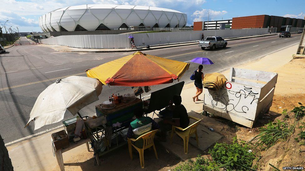 Vendors sit in front of the Arena de Amazonia 26 June 2015