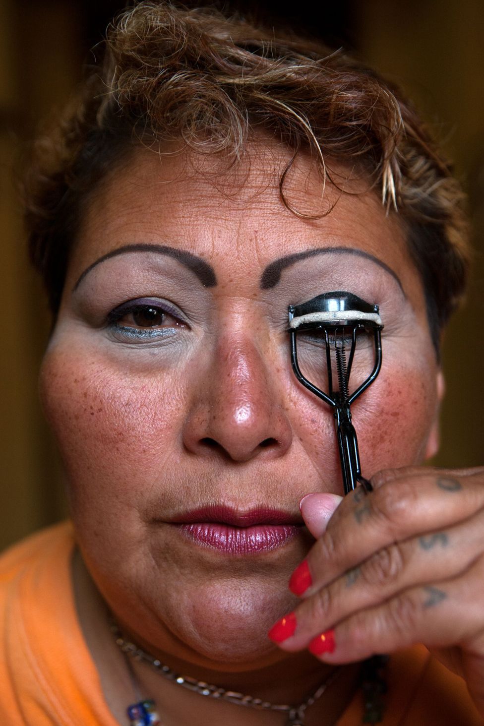 Paola, a resident at Casa Xochiquetzal, puts on make-up before going to work