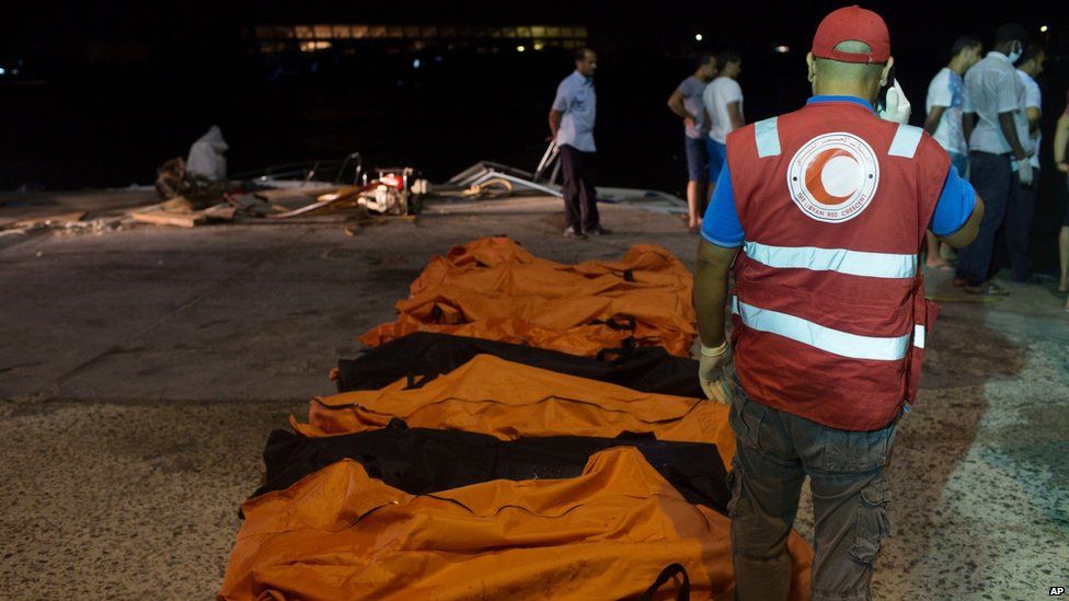 Rescuers gather around the bodies of drowned migrants in Zuwara, Libya (27 August 2015)