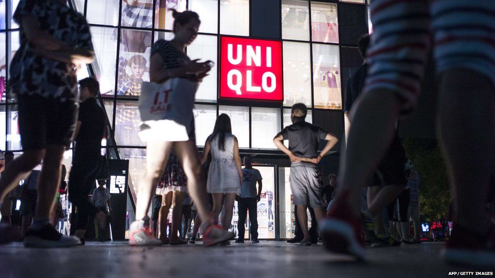 In this picture taken on July 15, 2015, people gather in front of a Uniqlo clothes store in Beijing.