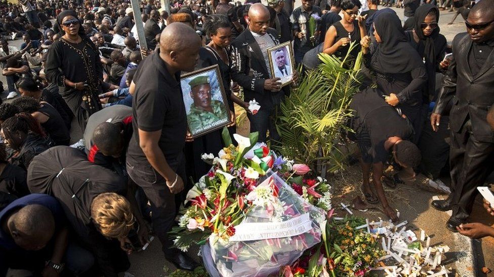 Mourners hold portraits of Burundian General Adolphe Nshimirimana during a vigil in Bujumbura on 9 August 2015