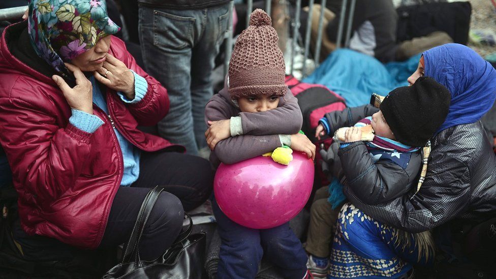 Children and women wait overnight to register at the makeshift camp at the Greek Macedonian borders near the village of Idomeni (07 March 2016)
