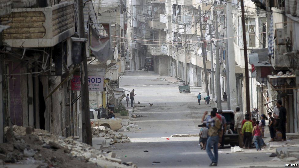 People walk in a street in the north-western city of Ariha, after a coalition of insurgent groups seized the area in Idlib province