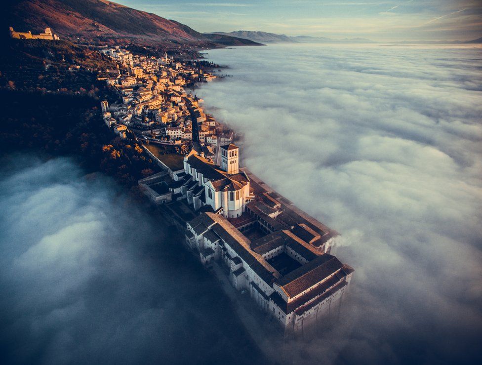 Basilica of Saint Francis of Assisi at sunset immersed in fog