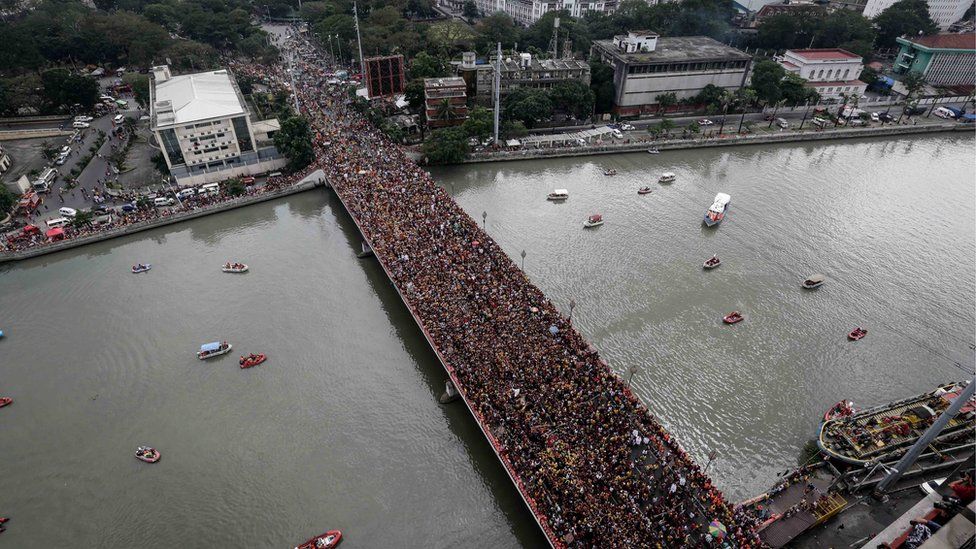 Huge crowds pack the Jones Bridge as the statue passes across it. Manila, Philippines, 9 January 2017.