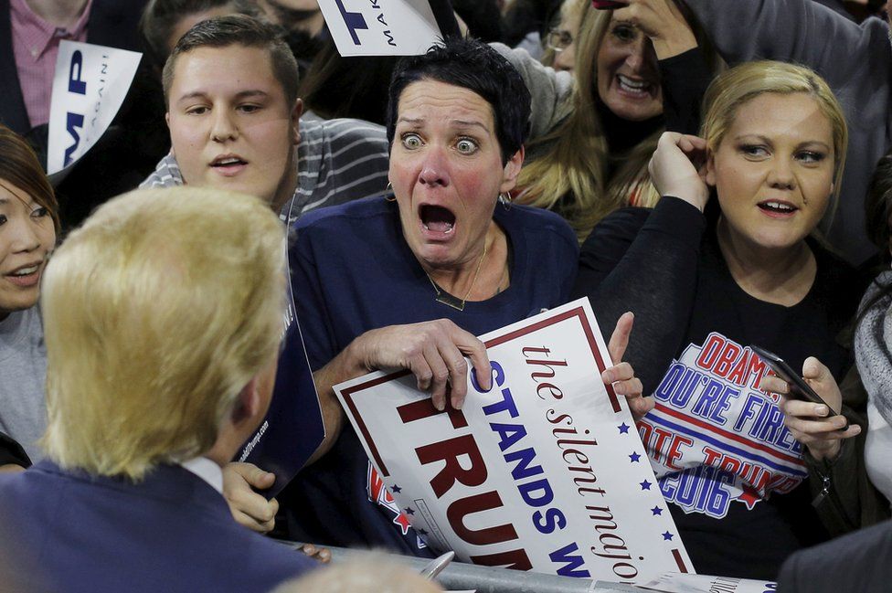 Miembro del público Robin Roy reacciona cuando Donald Trump la saluda en un acto de campaña en Massachusetts.