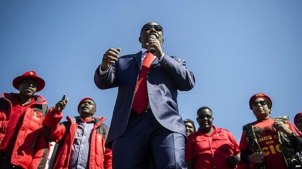 South African opposition party Economic Freedom Fighter ( EFF) leader Julius Malema (C) addresses his supporters after his corruption trial was postponed on August 3, 2015 outside the High Court in Polokwane, South Africa