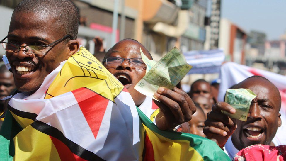 Protesters holding old Zimbabwe dollar notes in Harare, Zimbabwe - Wednesday 3 August 2016