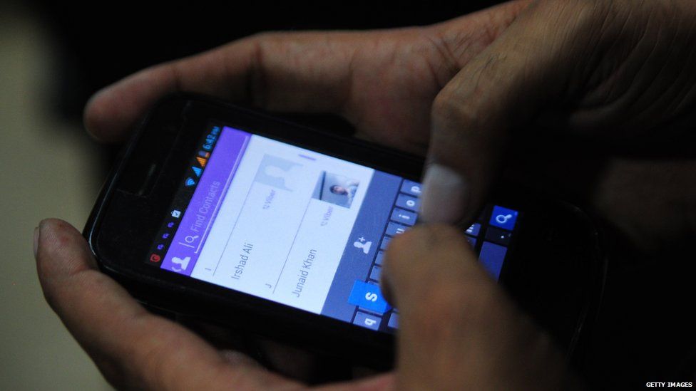 A Pakistan man tries to connect to chat with his friend on his mobile in the port city of Karachi