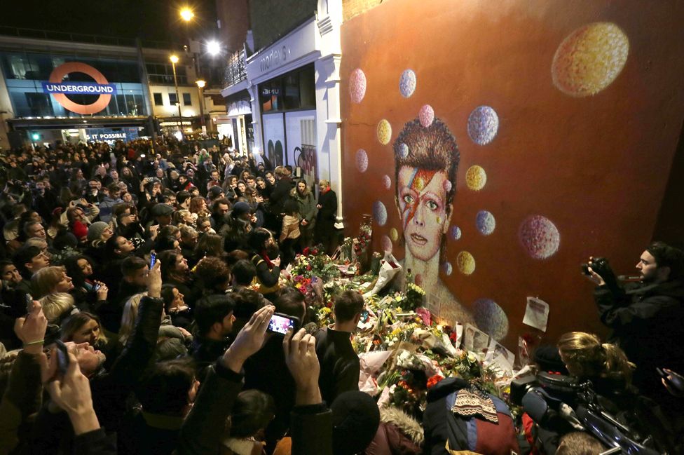 People gather at a mural of singer David Bowie by artist Jimmy C, in Brixton, south London.倫敦南部,民眾在一幅由吉米·C創作的大衛·鮑伊壁畫前致敬