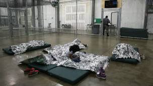 Una niña duerme en una colchoneta en un centro de detención fronterizo